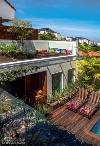 Sob medida para proteger a varanda, o beiral de 80 cm foi montado com vidro laminado incolor (10 mm) e apoiado em estrutura de alum&iacute;nio com acabamento de a&ccedil;o corten (se&ccedil;&otilde;es de 1 m, execu&ccedil;&atilde;o da Bergel). Cabos de a&ccedil;o encapados servem de guia para a trepadeira sapatinho-de-judia. Almofadas da Lisa Corti. Projeto do arquiteto Erick Figueira de Mello.