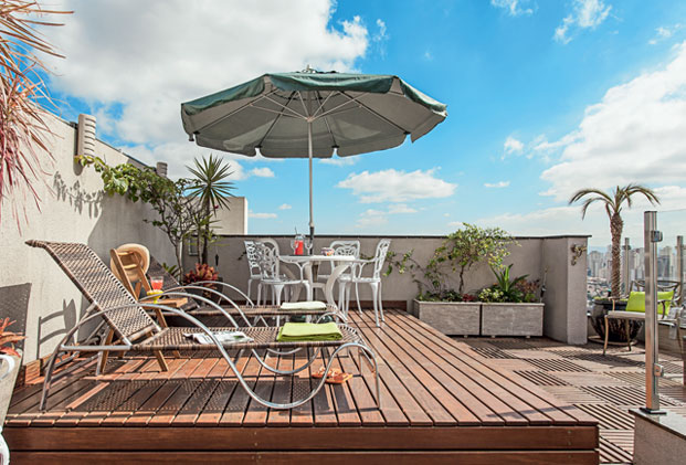 Telhado cinza de prédio vira solário com chuveirão e plantas