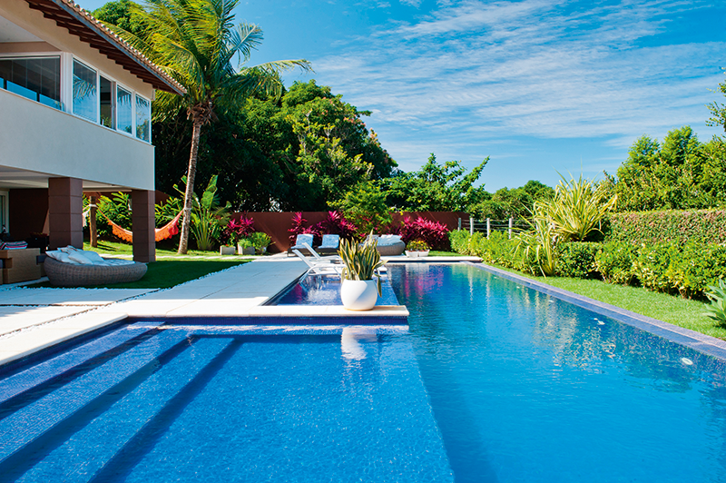 Após uma bela reforma, a antiga piscina desta casa se transformou num templo de lazer nas mãos do arquiteto André Oliva, de Salvador. Com 84 m², a nova caixa de concreto revestida de pastilhas de porcelana (Cerâmica Atlas) reúne área de convívio, prainha, spa e raia.