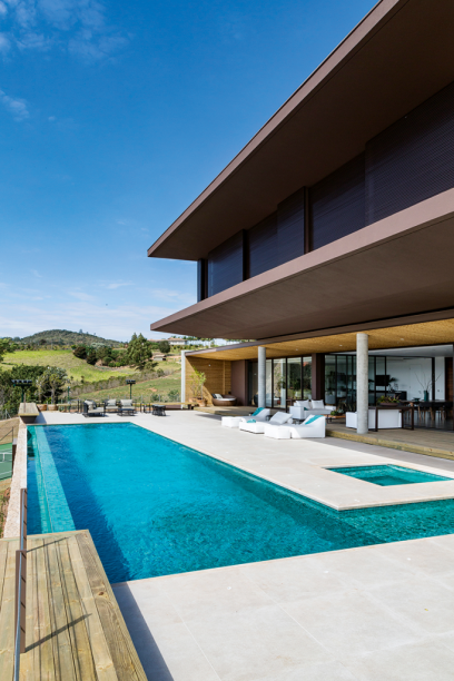 Nessa casa de campo, o ponto mais alto do terreno, a área da piscina foi brindada com um amplo panorama – e permite ainda acompanhar as partidas de tênis na quadra embaixo. O tanque exibe pastilhas verdes no tom Bermuda (5 x 5 cm, da Cerâmica Atlas, na Mais Revestimentos). No piso, travertino romano bruto fornecido pela Beija-Flor Madeireira & Marmoraria.