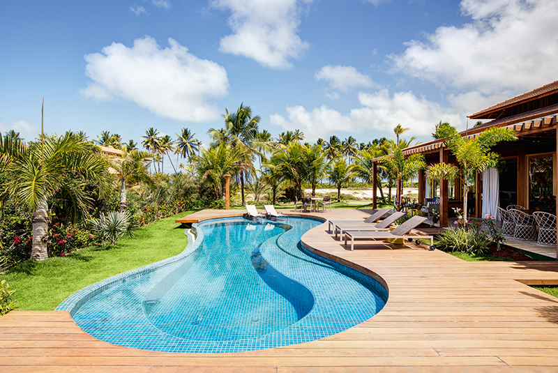 Com desenho orgânico e borda infinita, esta piscina é lugar de lazer e de boas conversas entre os integrantes da família numerosa. O deck de ipê hidratado com óleo de linhaça faz as vezes de borda do reservatório revestido de pastilha cerâmica (Portobello). O tanque mede cerca de 4 x 15 m.