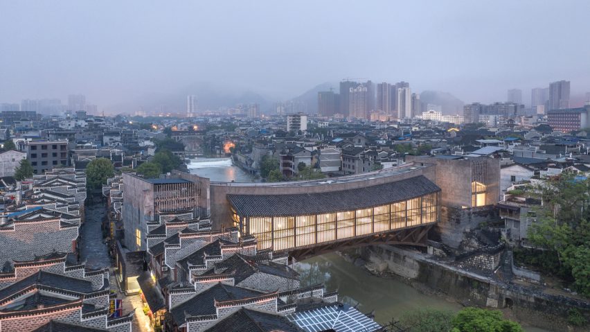 Jishou Art Museum, China, por Atelier FCJZ – O arquiteto americano-chinês Yung Ho Chang, do Atelier FCJZ, criou uma ponte para pedestres em Jishou (China), que funciona como um museu com a intenção de incentivar os habitantes locais a se envolverem com a arte enquanto passam pela cidade. O Museu de Arte de Jishou é coberto por telhas que podem ser vistas em toda a cidade, ajudando a estrutura a se misturar com o ambiente, enquanto a parte inferior se assemelha a uma rua coberta com treliças de aço abertas.