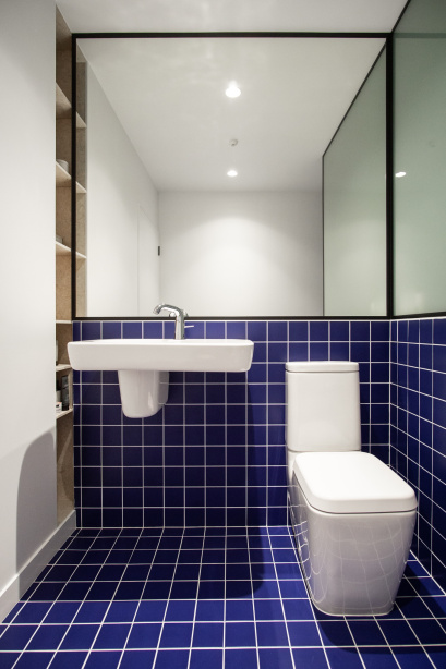 Banheiro com piso e meia parede de azulejos azuis escuros