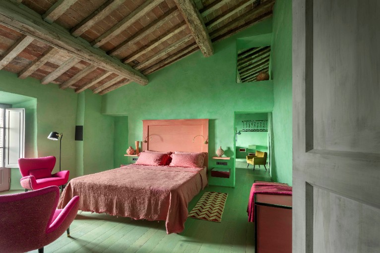 quarto com parede verde e cama rosa