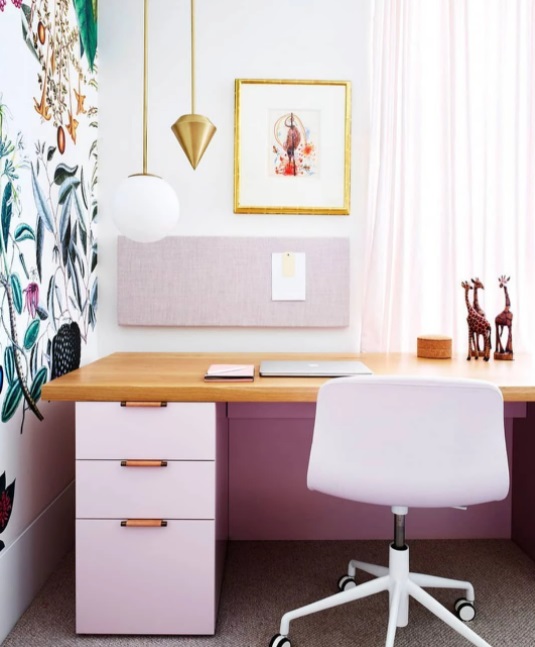 Home office com móveis rosa claros. Parede com papel de parede botânico