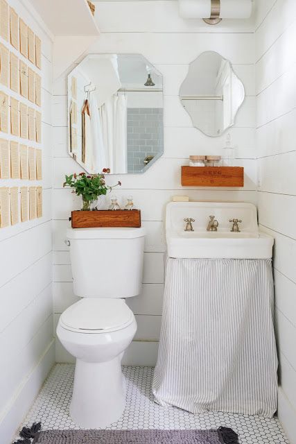 Banheiro branco, com peças na mesma cor e parede com dois espelho lado a lado de tamanho e formato diferentes