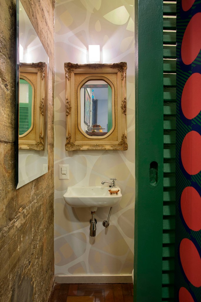 Lavado com espelho com moldura neoclássica. Papel de parede geométrico