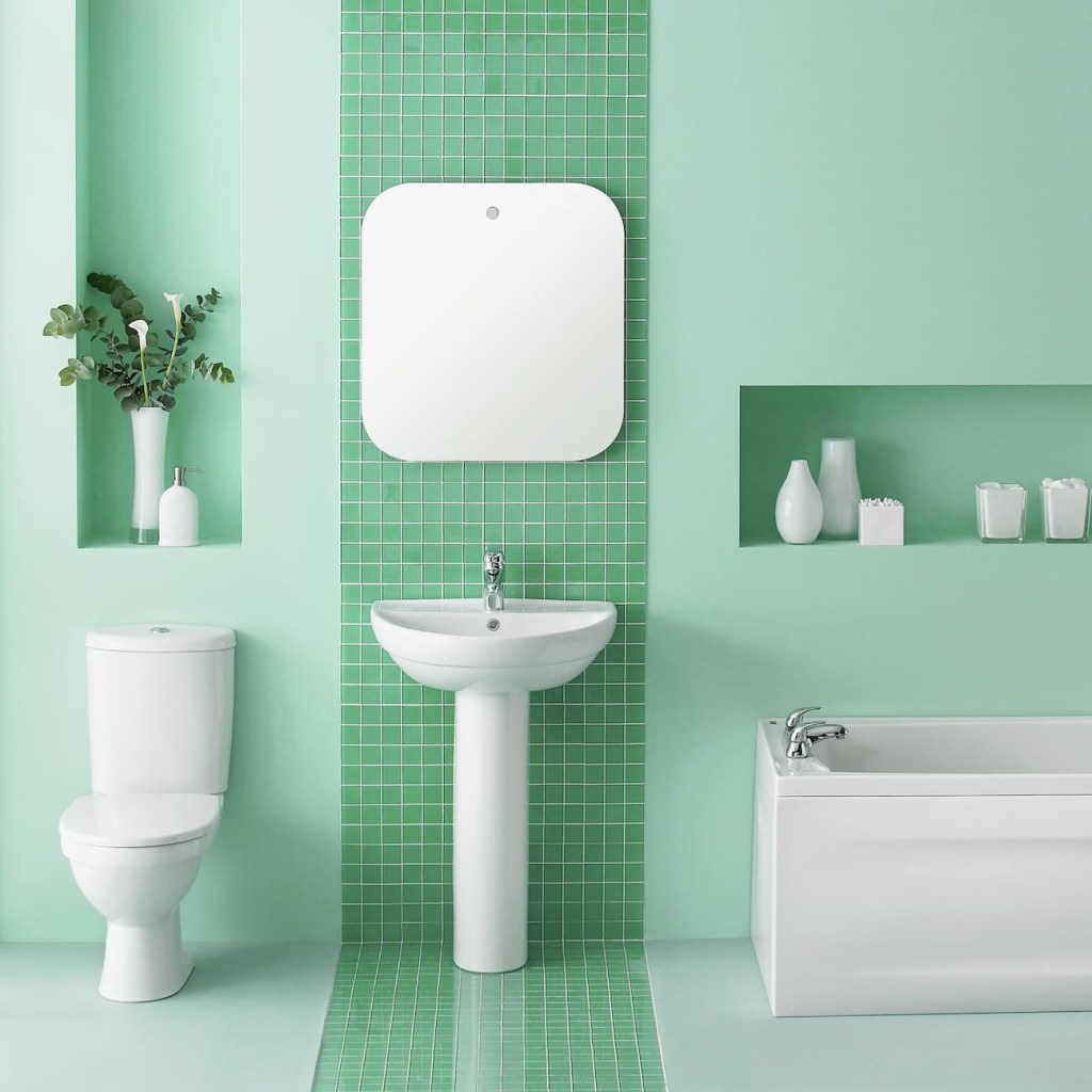 Banheiro verde claro vibrante com vaso sanitário, pia e banheira brancos