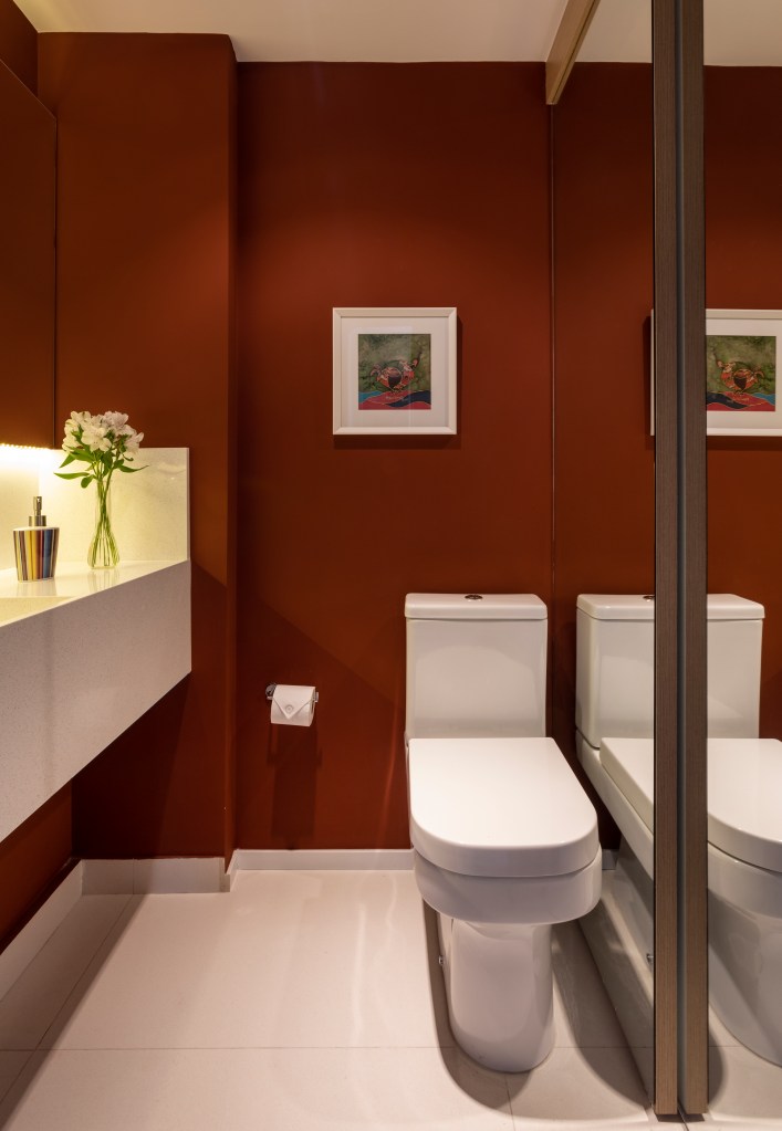 lavabo com armário porta de correr com espelho e paredes na cor terracota