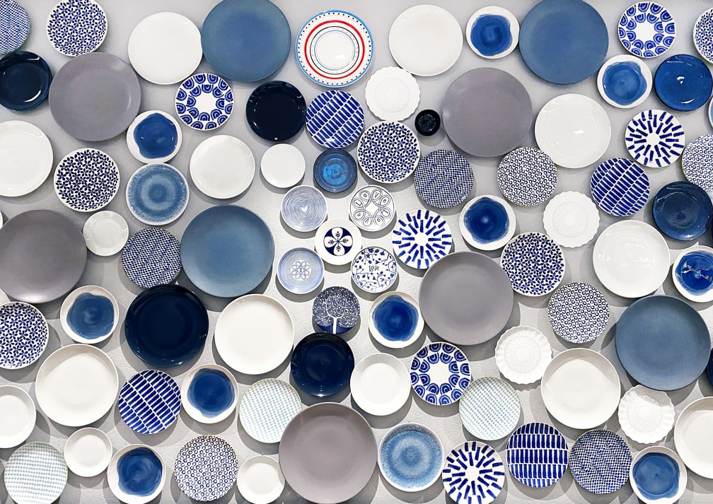 Composição com diversos pratos azuis e brancos em fundo branco