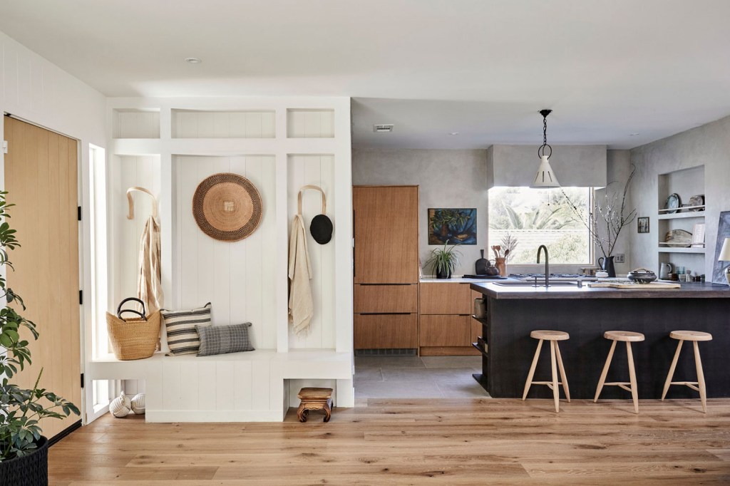 Sala de estar com cozinha integrada. Tons de madeira, branco e preto se mesclam para criar ambiente aconchegante