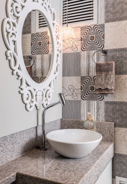 Apesar da predominância de revestimentos brancos, o banheiro social ganhou toques especiais. O espelho com a moldura toda trabalhada é um deles. Mas o destaque fica por conta da parede forrada pelo patchwork de porcelanato. Projeto Camila Chalon. Apesar da predominância de revestimentos brancos, o banheiro social ganhou toques especiais. O espelho com a moldura toda trabalhada é um deles. Mas o destaque fica por conta da parede forrada pelo patchwork de porcelanato. Projeto Camila Chalon.