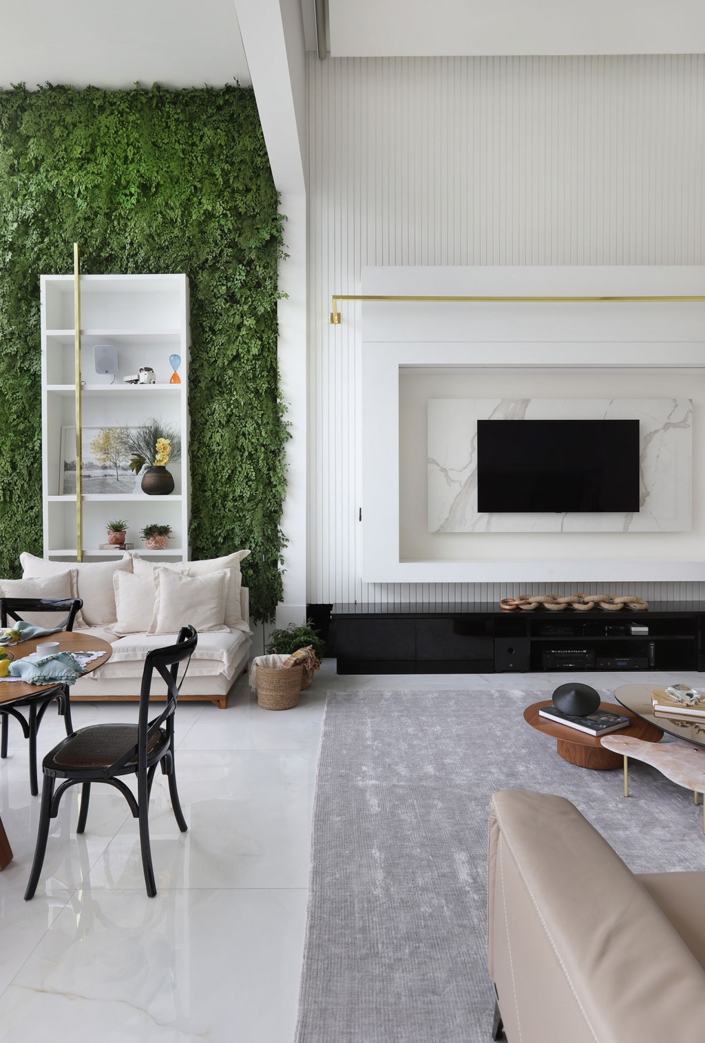 Apê ganha automação customizada e destaca pé direito duplo com biofilia