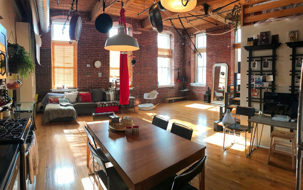 Loft de estilo industrial com tijolinhos na parede e integração de ambientes