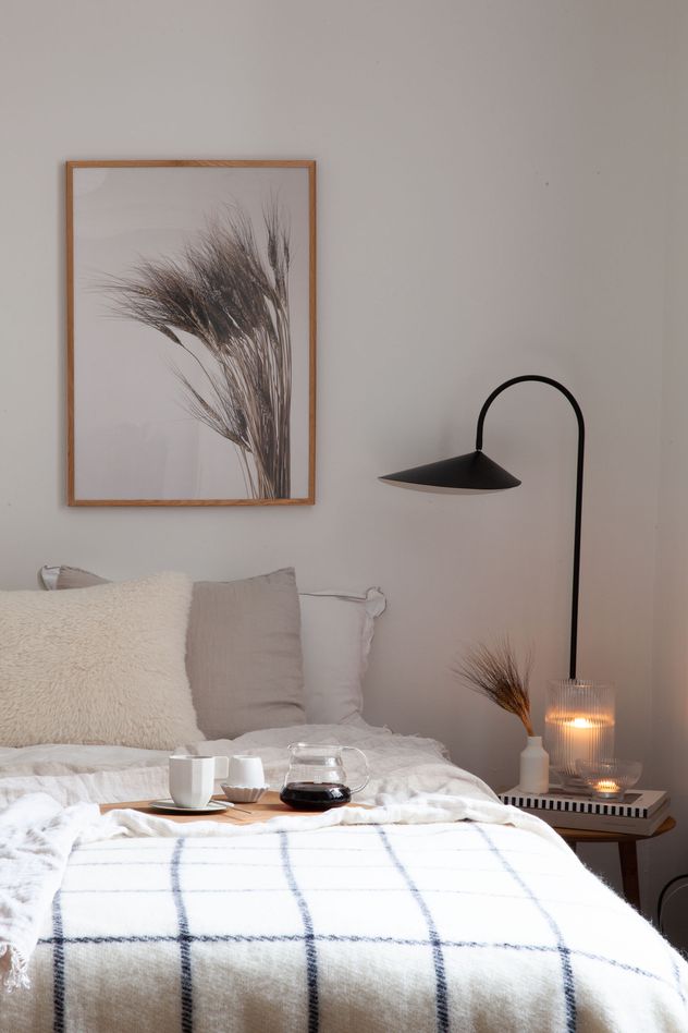 Um quadro de planta, em preto e branco, &eacute; exibido neste quarto majoritariamente branco