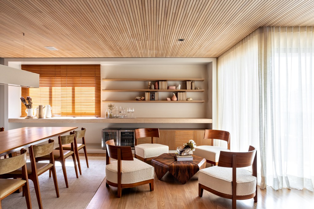 Sala integrada com décor neutro e muita madeira