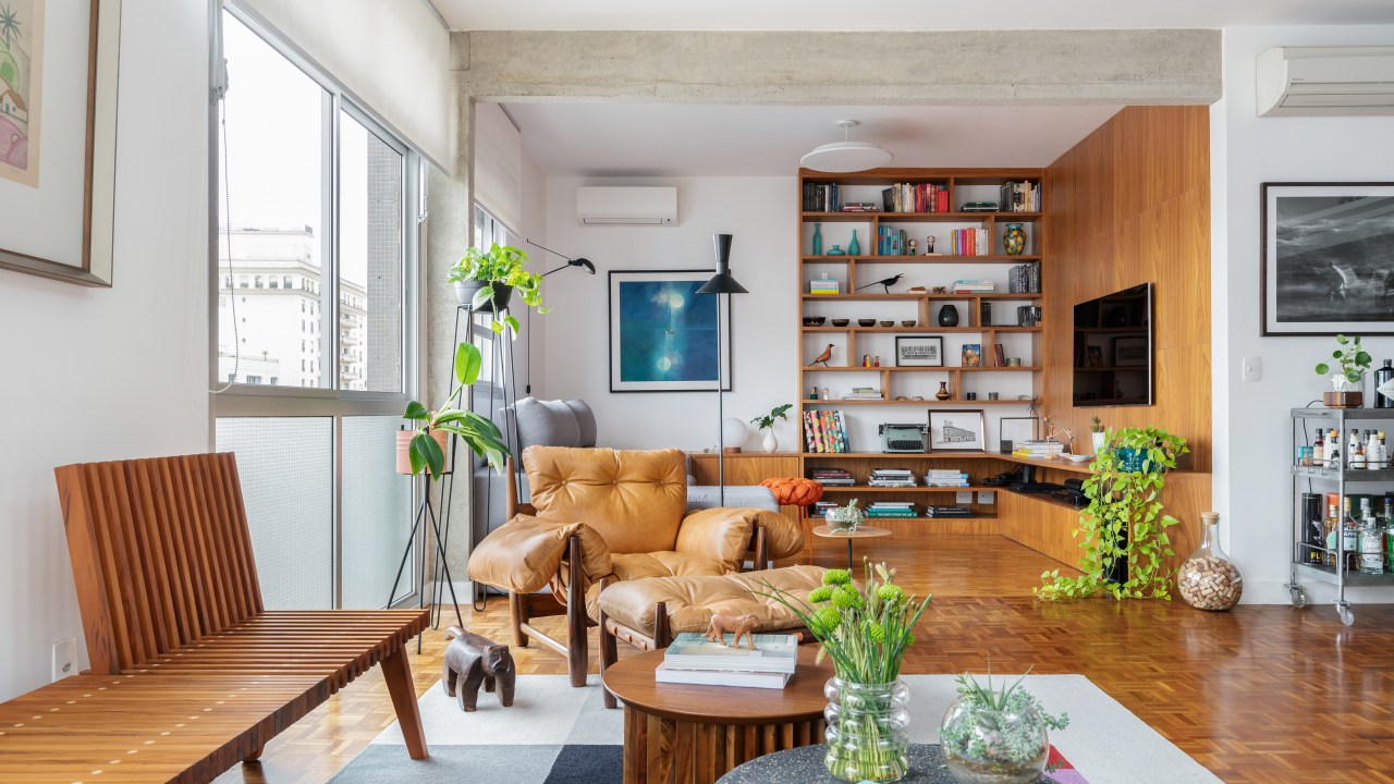 Sala de estar com muita madeira, livros e cores