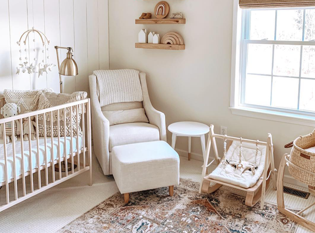 Quarto de bebê com decoração neutra, berço, poltrona de amamentação e brinquedos