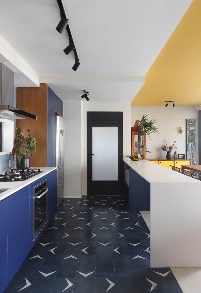 Cozinha com marcenaria azul e piso em ladrilhos
