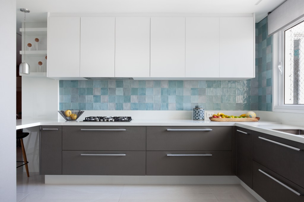 Cozinha com marcenaria clara e backsplash azul