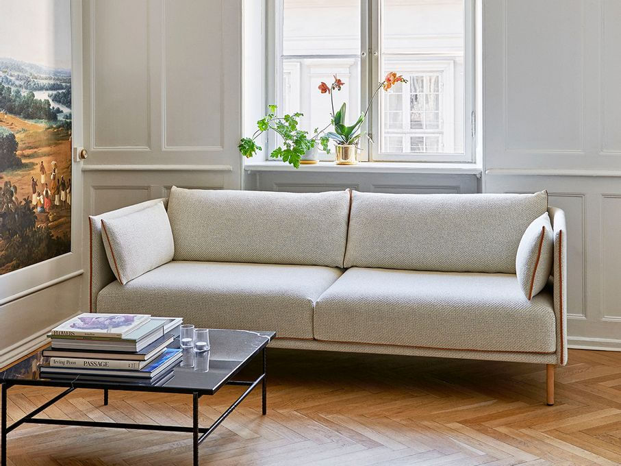 Sala com sof&aacute; branco e vaso na janela