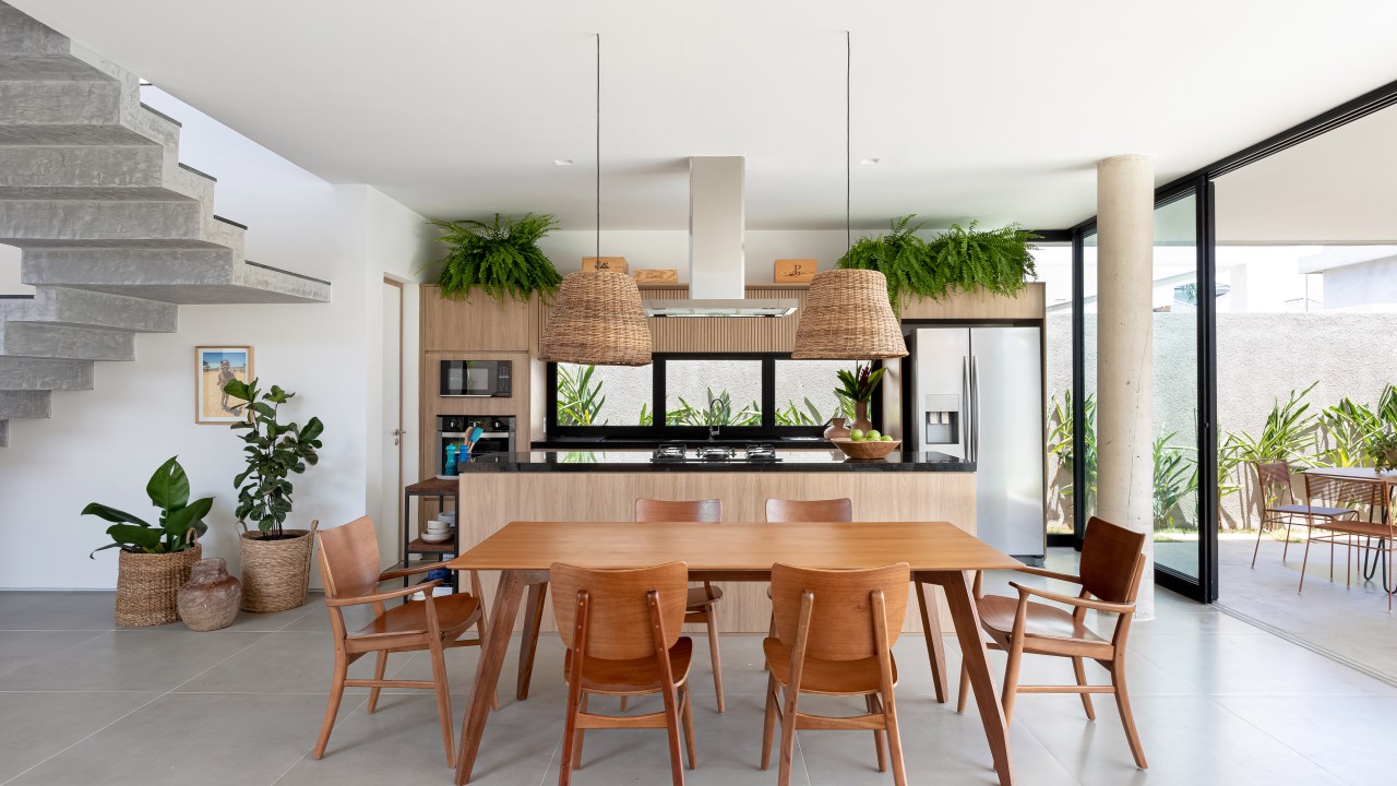 Sala de jantar integrada com cozinha; mesa de jantar de madeira