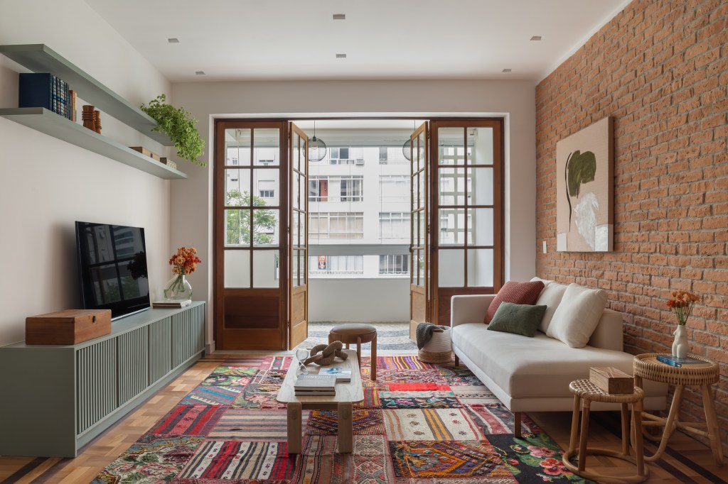 Ladrilhos e móveis em madeira dão toque retrô a apê de 145m²