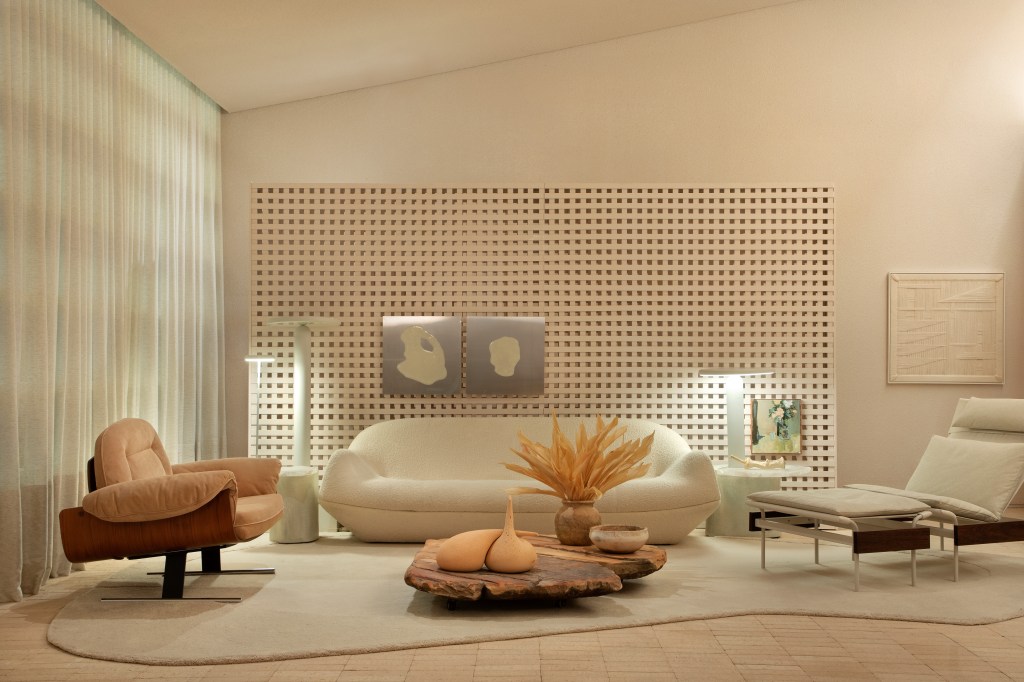 Loft de 120 m² é inspirado no caramujo aruá-do-mato. Projeto de Très Arquitetura para a CASACOR SP 2023. Na foto, sala com parede de muxarabi, poltrona e sofá curvo.