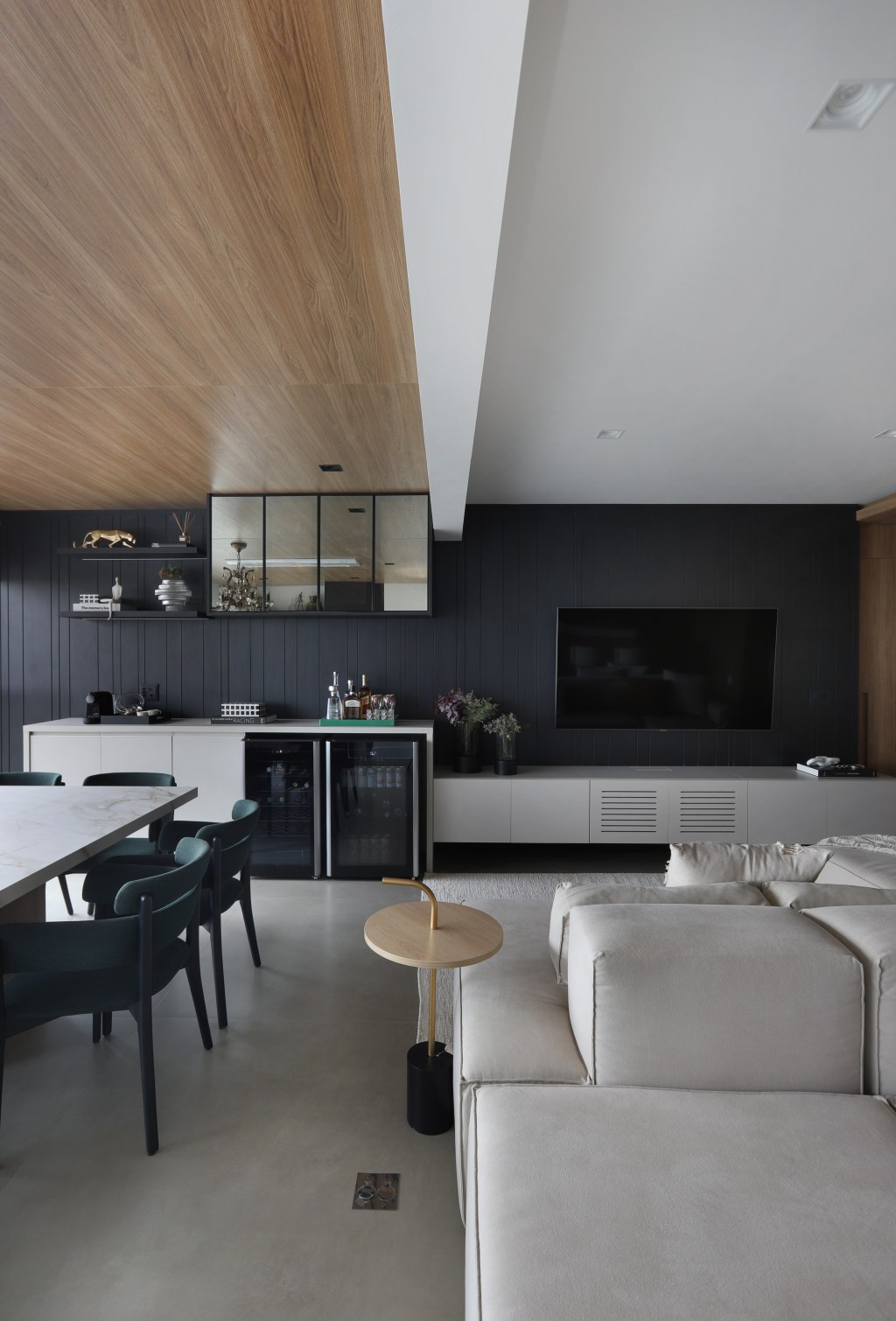 Painel de madeira percorre parede e teto da área social do apê de 120 m²