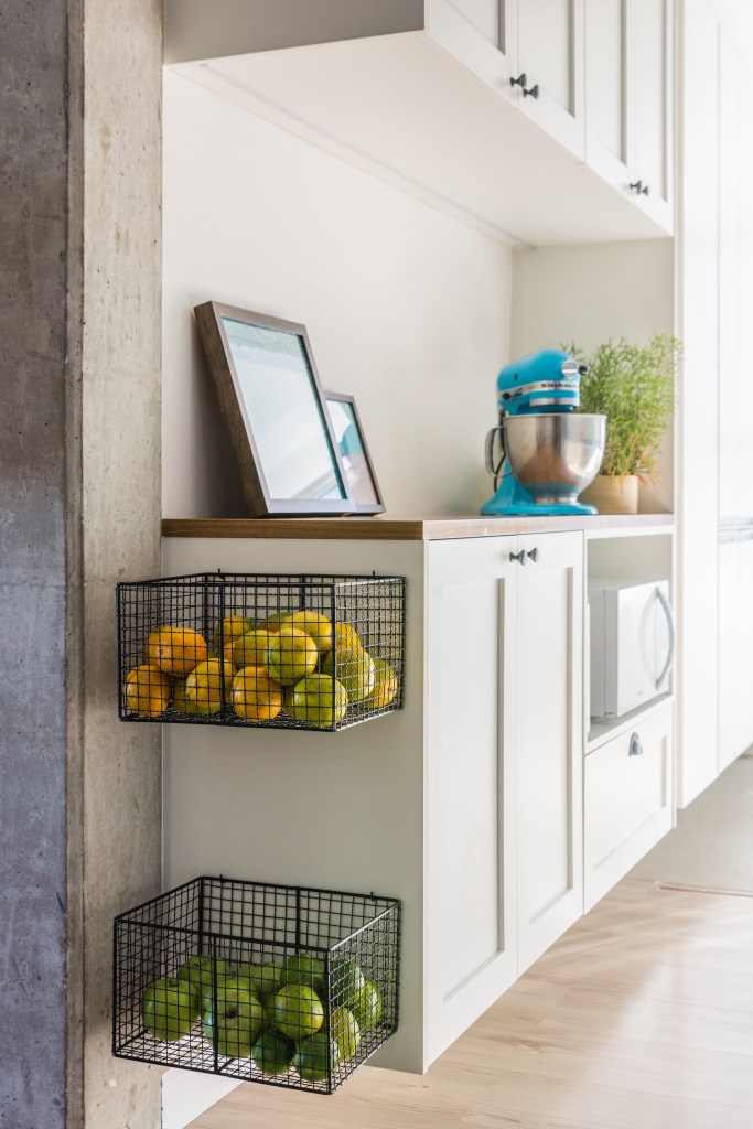 Cestos na decoração. Projeto de Studio Guadix. Na foto, cozinha com marcenaria branca e cestos com frutas.