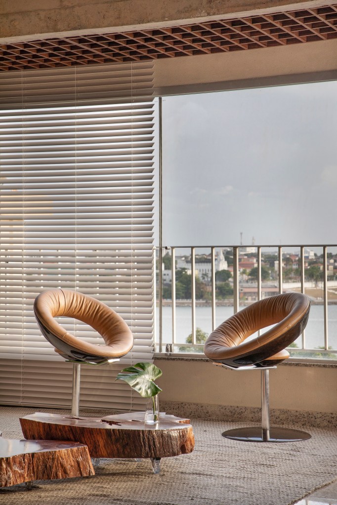 Projeto de Roby Macedo. Na foto, Poltronas em couro na frente de janela com persiana.