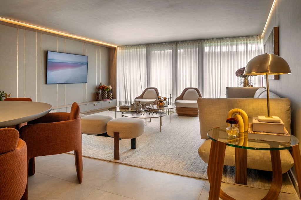 Apartamento de 189 m² tem décor afetivo e repleto de peças autorais. Projeto de Vivian Maia para a CASACOR Brasília 2023. Na foto, sala de estar com tapete. sofá, tv e poltronas.