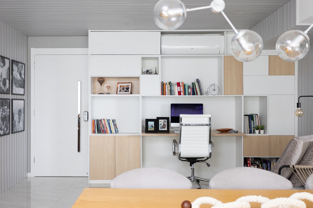 Home office ganha destaque na entrada deste apê de 147 m². Projeto de Bruna Bittencourt. Na foto, home office com ripas na parede e teto. Fotos de familia.