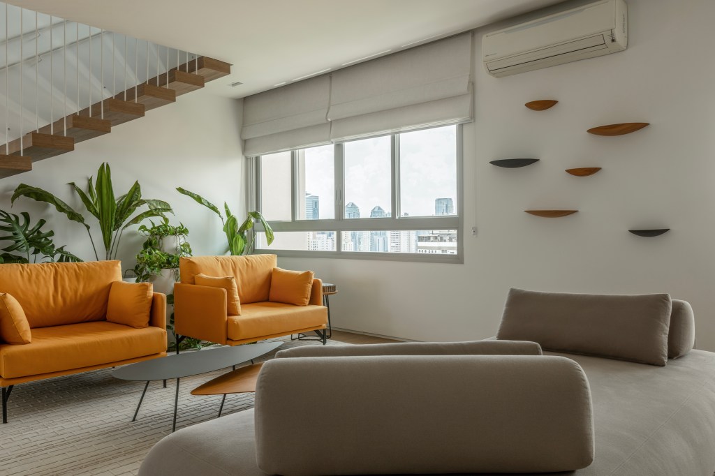 Reforma transforma apartamento de 362 m² em refúgio urbano minimalista. Projeto Inovando Arquitetura. Na foto, hall com poltrona laranja e escada.