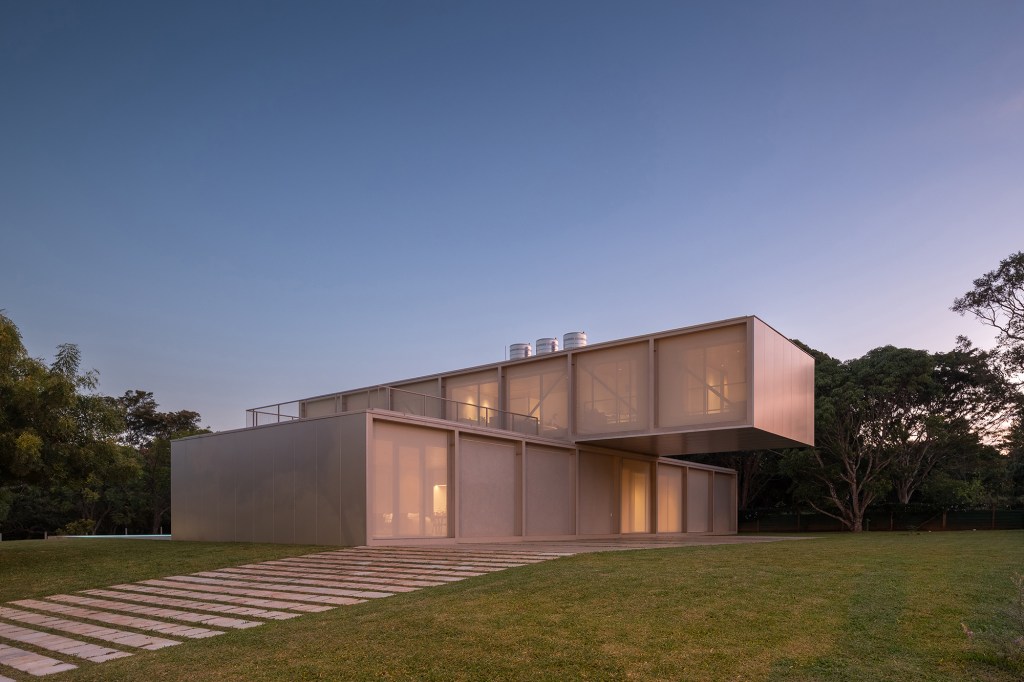 Dois volumes sobrepostos compõem esta casa de 500 m² em Brasília. Projeto de Bloco Arquitetos. Na foto, fachada com jardim.