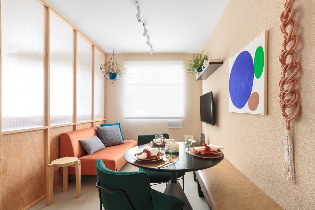 Painel translúcido e banco como rack otimizam o espaço em apê de 24 m²